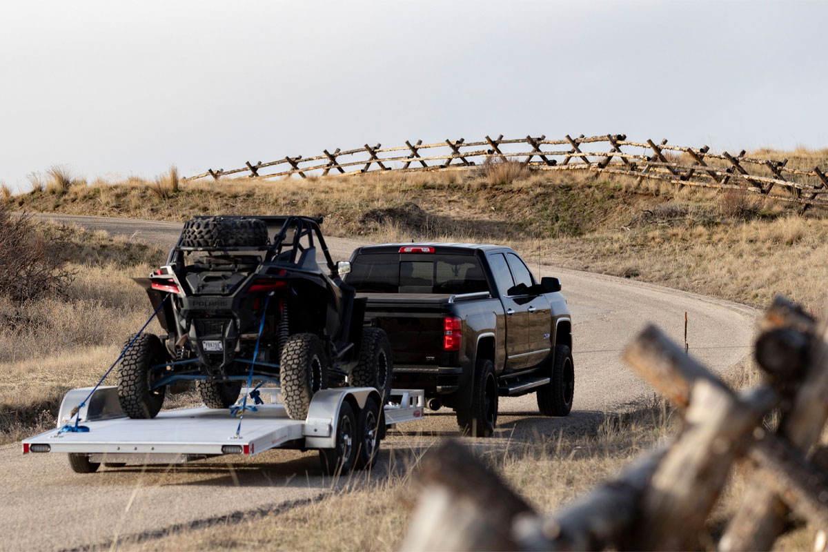 Black Truck Hauling Open High Country Car Hauler Trailer With Loaded ATV