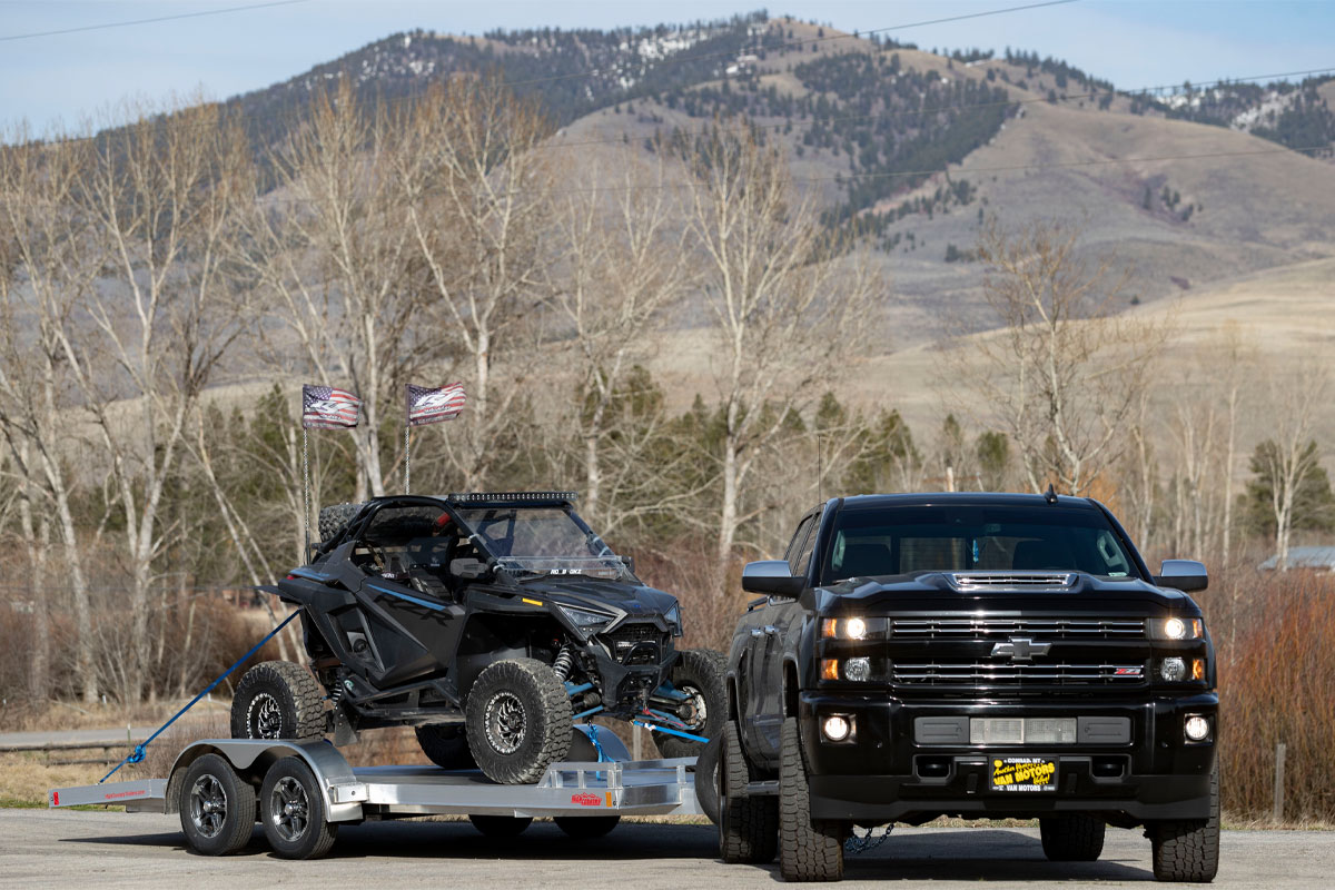 Black Truck Hauling Open High Country Car Hauler Trailer With Loaded ATV