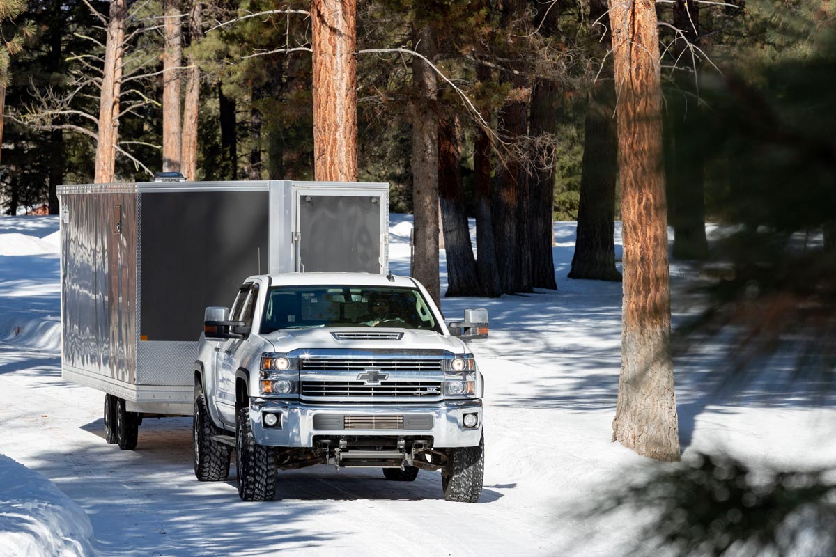 Enclosed Deckover 101" Wide Snow Grey Trailer Driving Through Forest