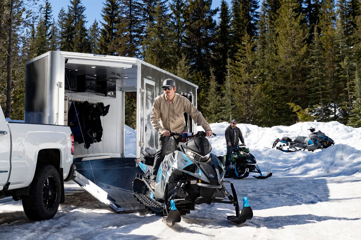 Guy Unloading Snowmobile Off All Sport Elevation Snow Trailer